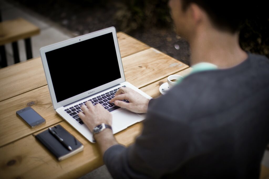 Mann am Schreiben auf dem Laptop