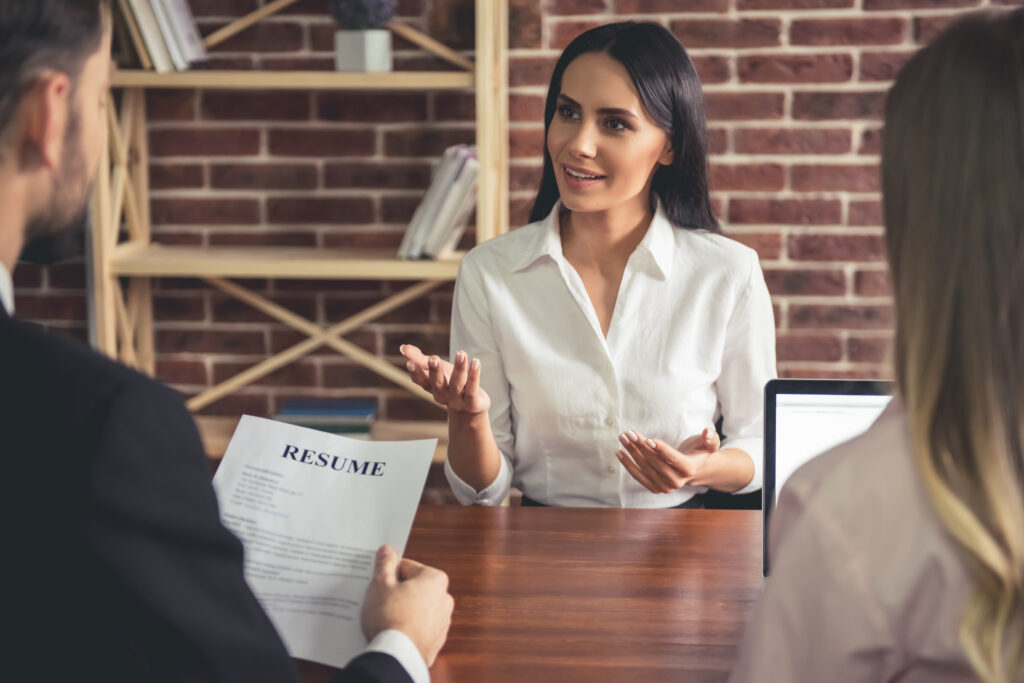 Frau am Bewerbungsgespräch mit zwei Personaler, Beautiful,Female,Employee,In,Suit,Is,Smiling,During,The,Job