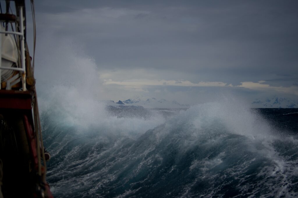 Schiff wird von Welle erfasst