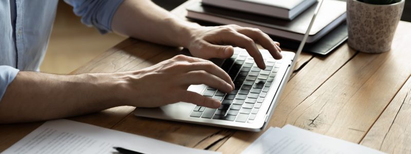 Closeup,Businessman,Using Laptop,Typing on Keyboard, sitting at a desk